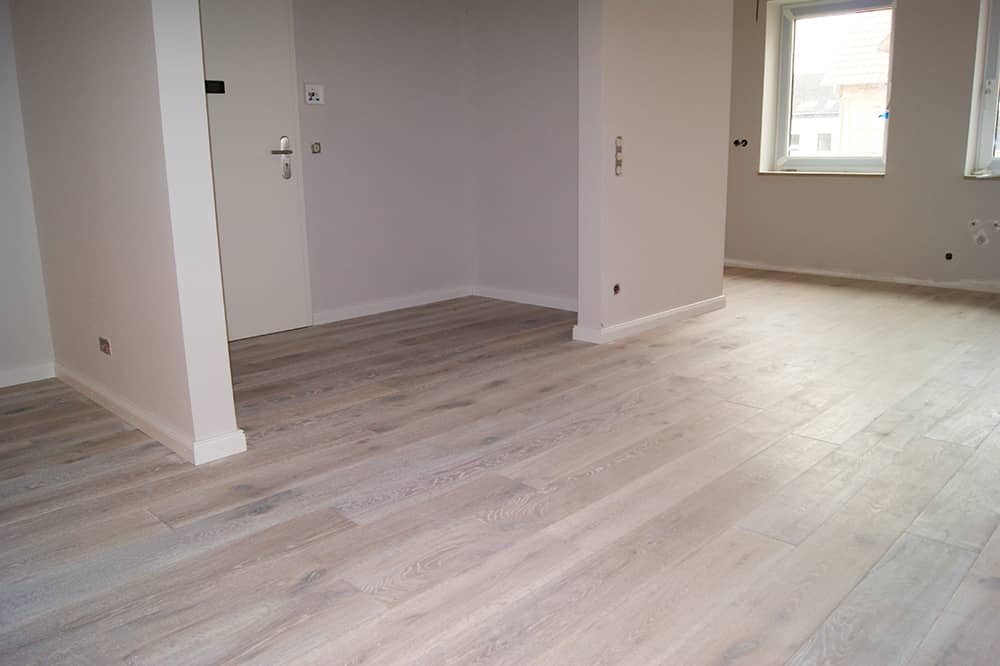 Grauer Parkettboden in einer leeren Wohnung