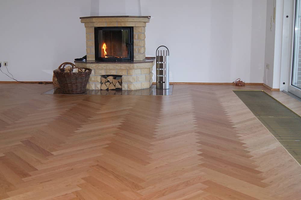 Parkett mit Fischgrätenmuster im leeren Wohnzimmer mit Kamin